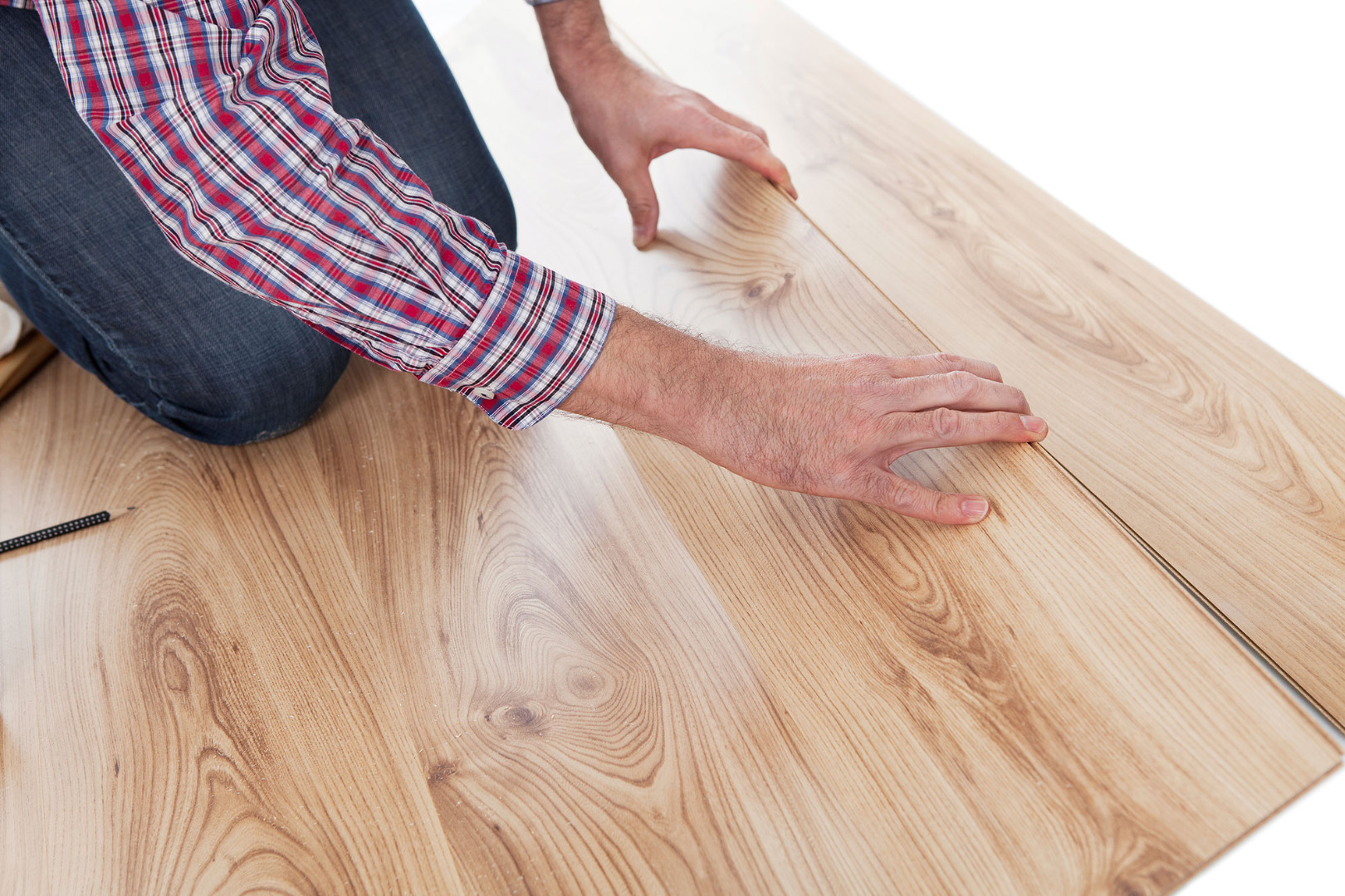 contractor in plaid shirt installing laminate flooring 